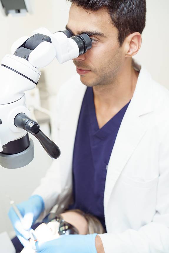 Dr. Lima working under a dental operating microscope